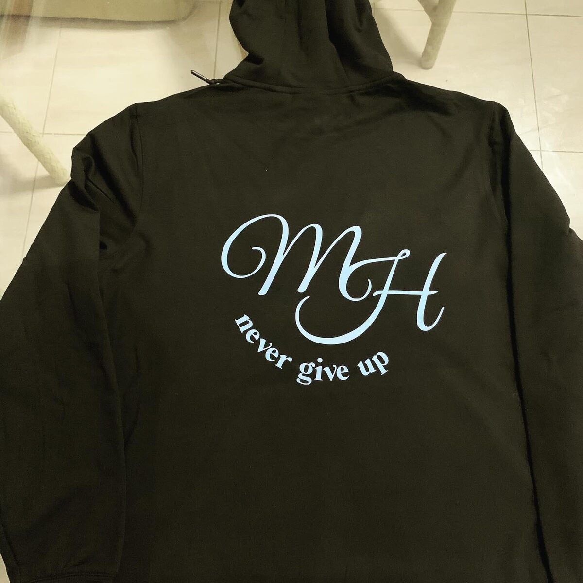 Olive green custom hoodie with a script monogram and the words never give up