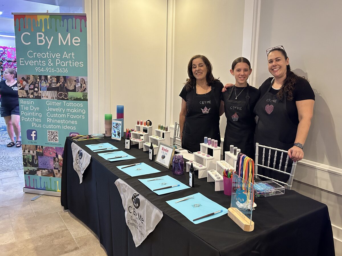 The C By Me team at their branded booth at a community event