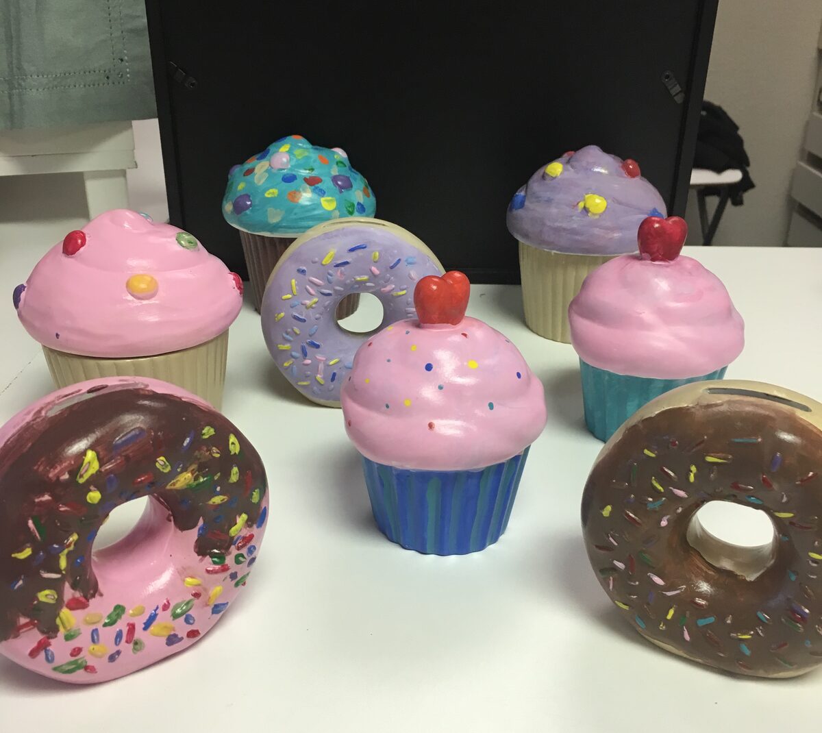 Painted ceramic cupcakes and donuts finished at a ceramics party