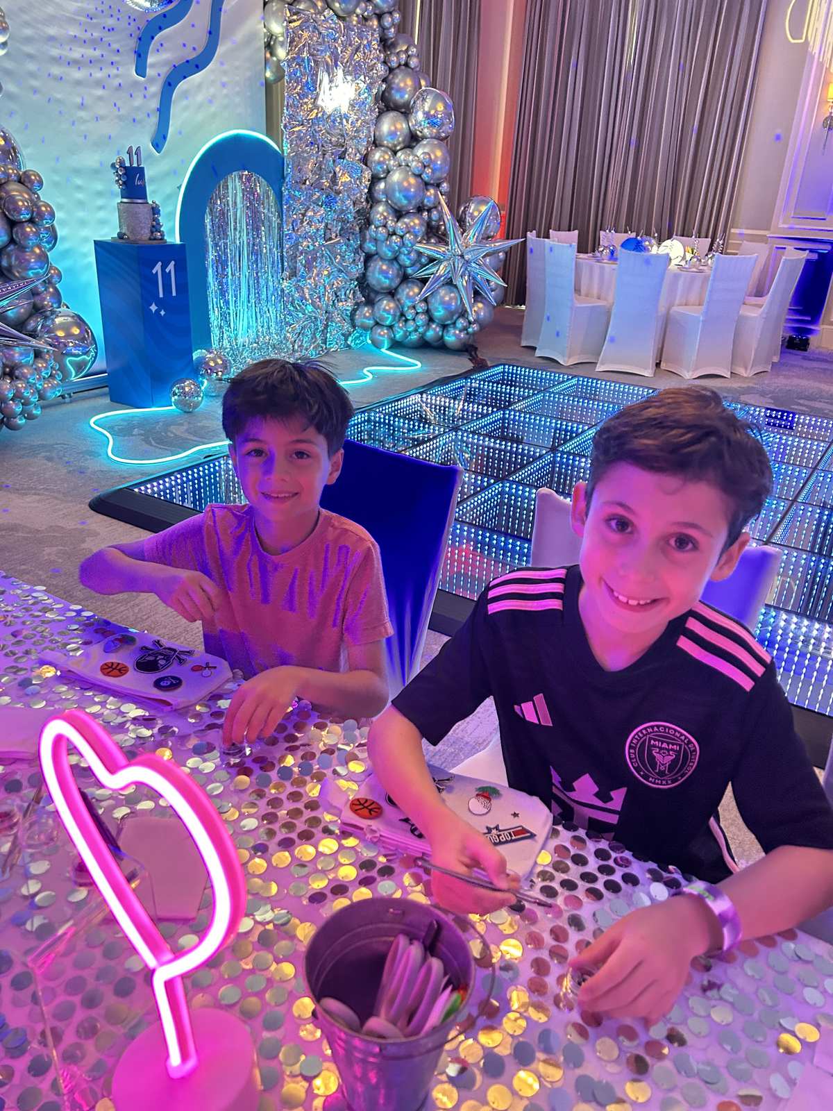 Boys at a craft station at a blue and silver themed mitzvah party