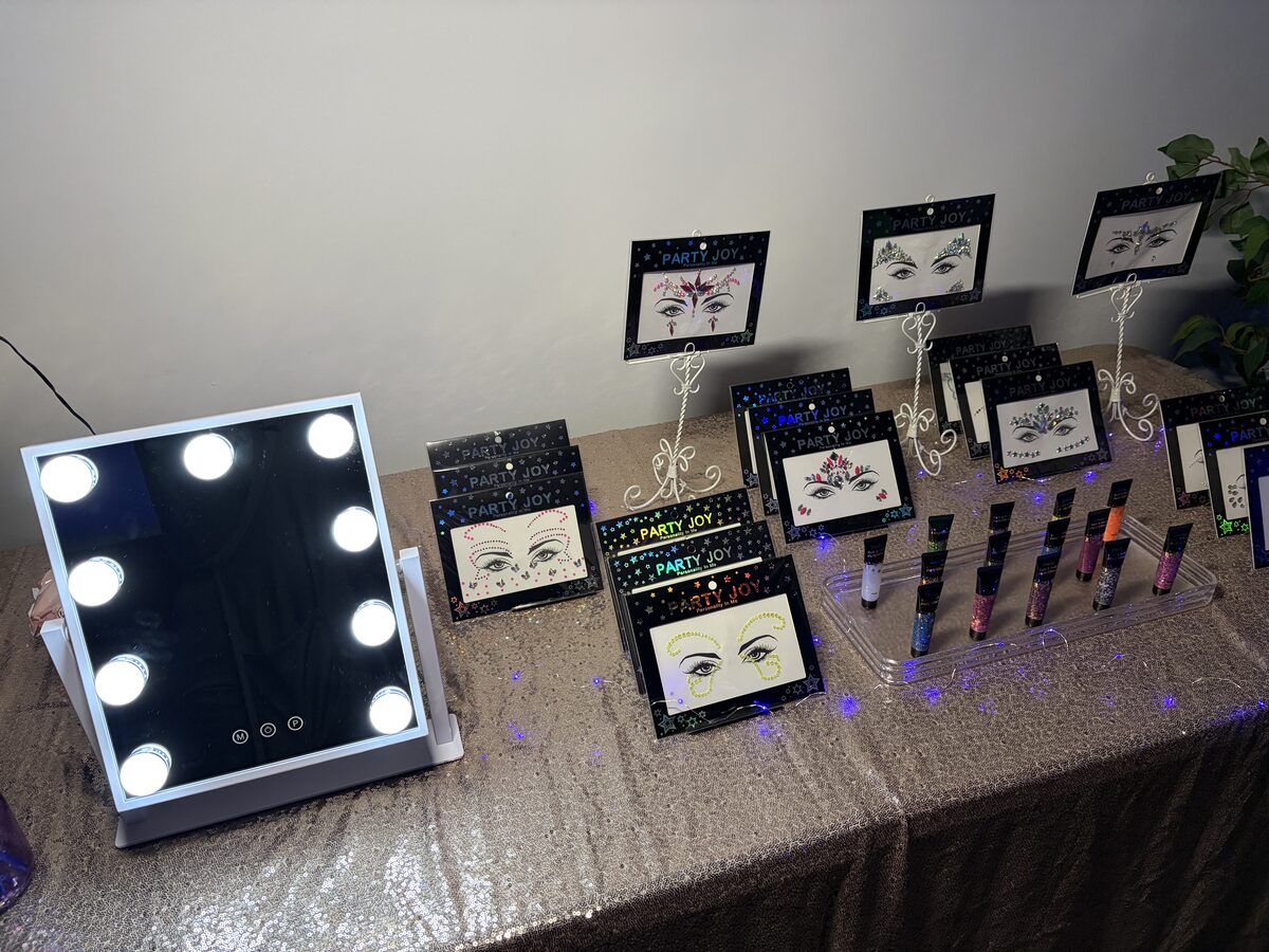 Face gem and glitter station set up with a lighted vanity mirror