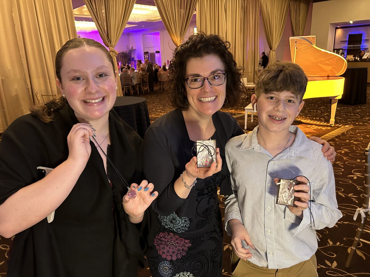 Family showing the resin pieces they made at a ballroom event station