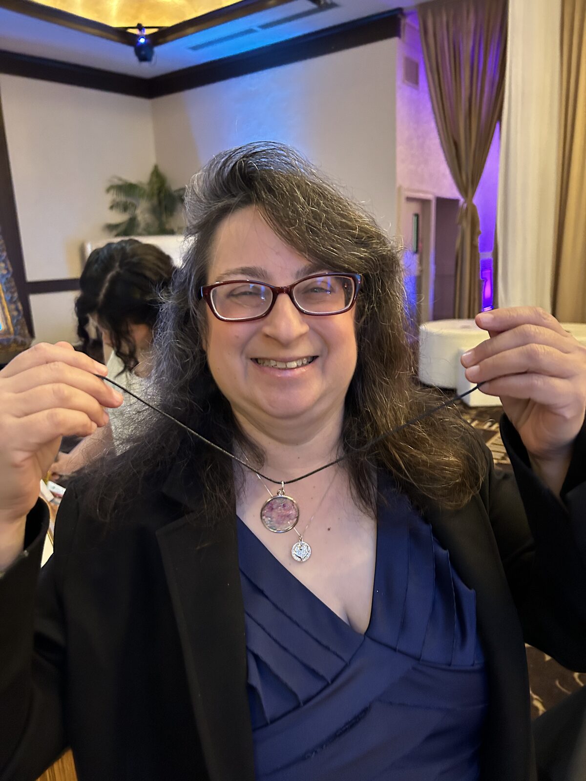 Guest wearing the resin necklace she made under event uplighting