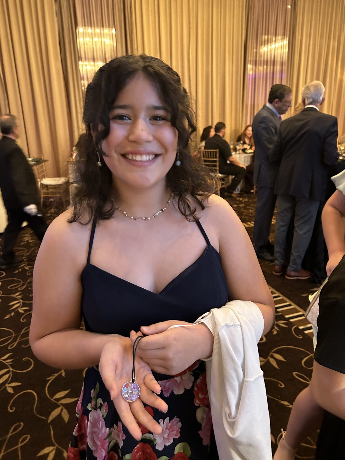 Teen guest holding her finished resin piece at a ballroom celebration