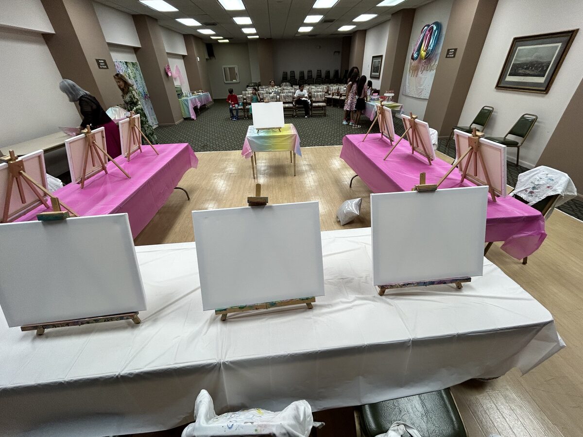 Canvas painting party set up with easels on pink linens