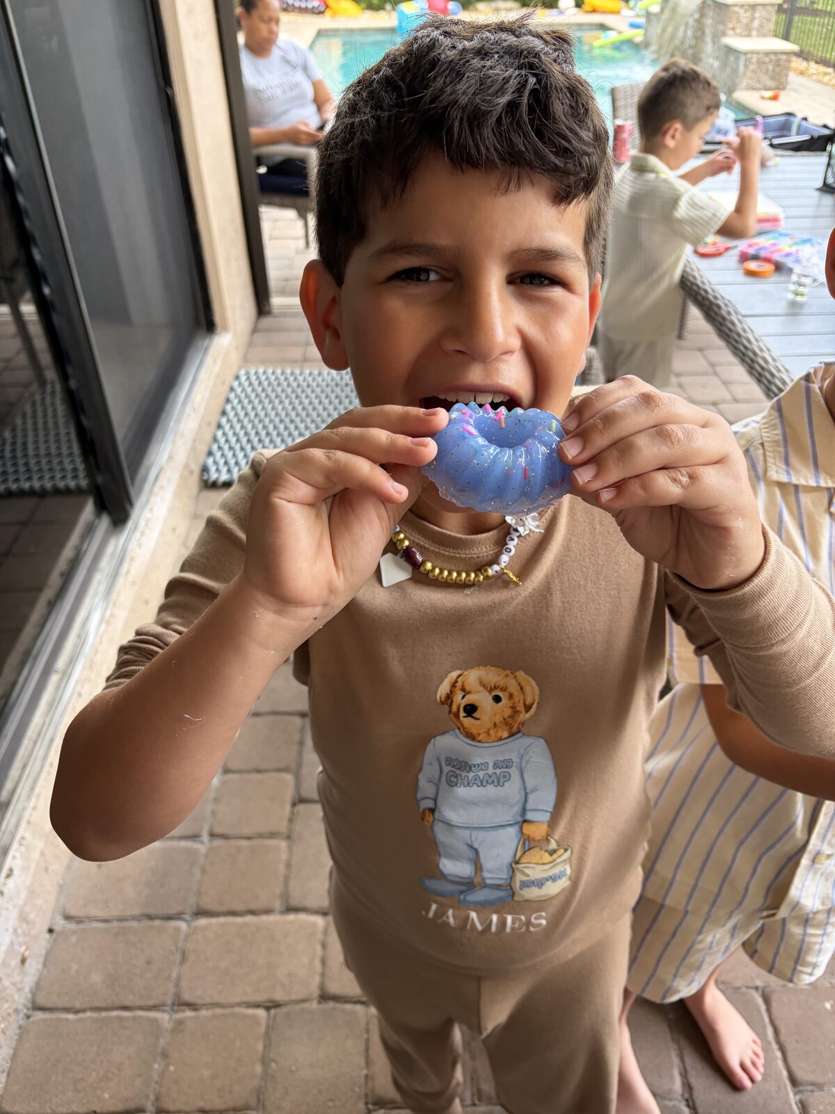Boy holding up a resin piece he made at a poolside party