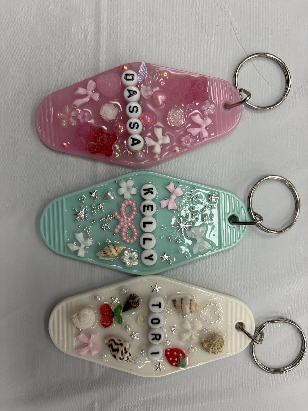 Three personalized resin keychains with names and embedded charms