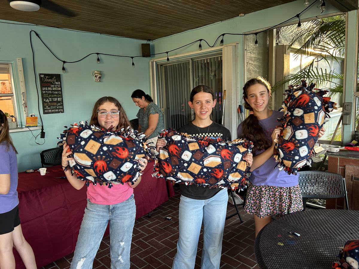 Students holding the fleece blankets they tied for a community service project