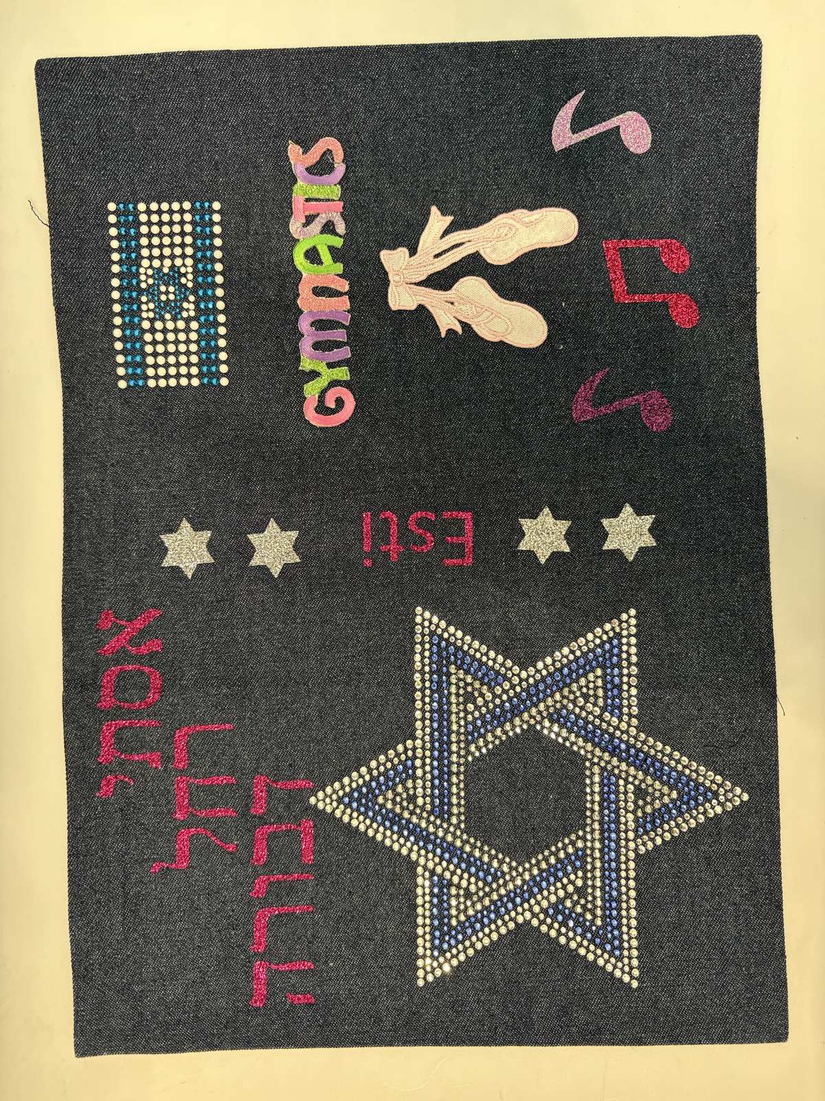 Denim siddur cover with a gold Star of David, gymnastics and music patches
