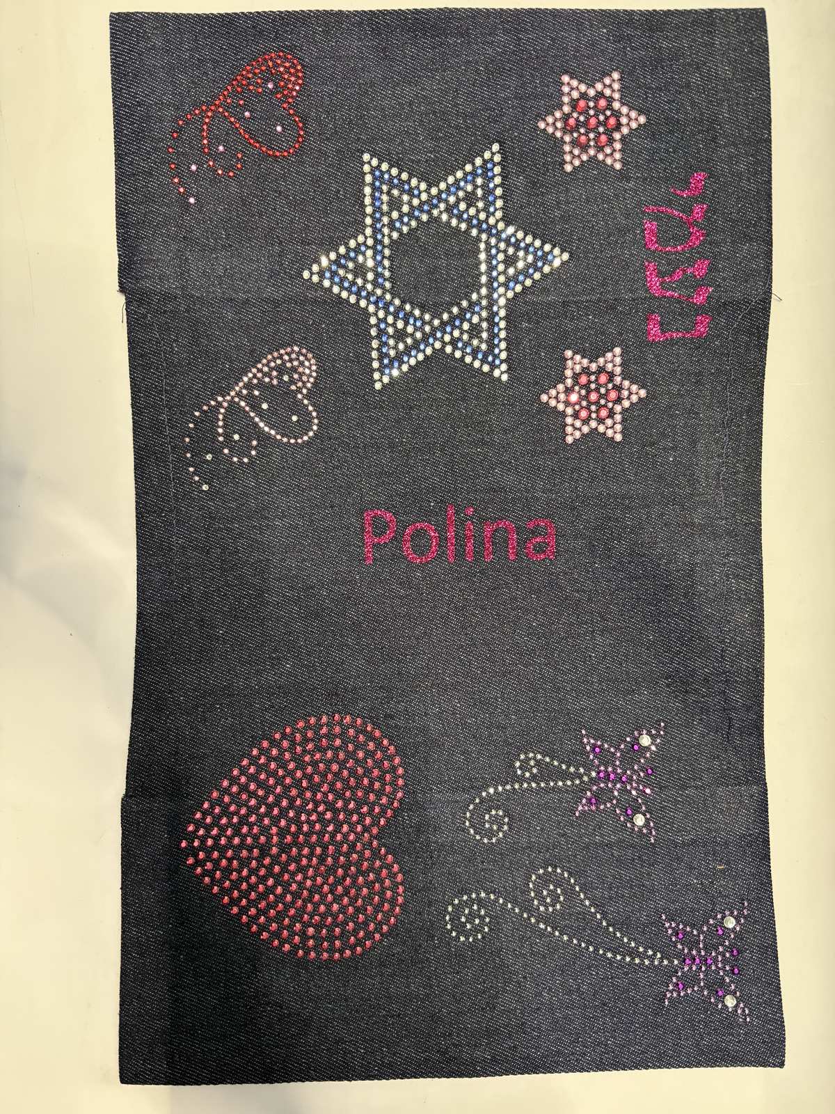 Denim siddur cover decorated with a rhinestone Star of David, hearts and a name