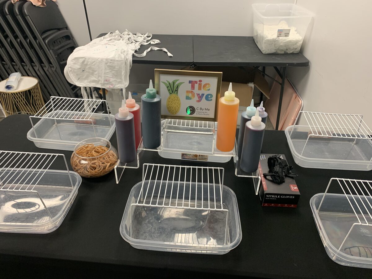 Tie dye station set up with squeeze bottles, racks and supply bins